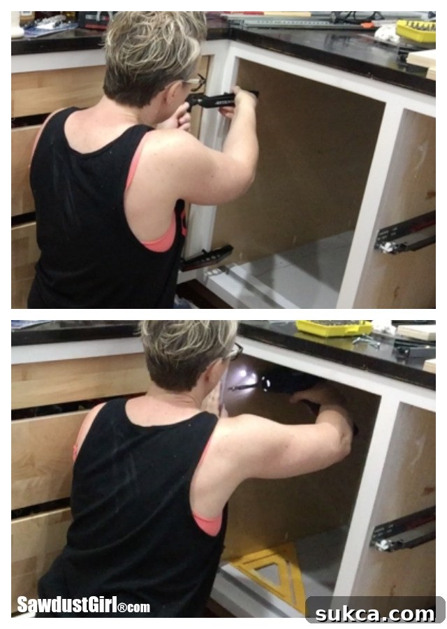 Working inside the cabinet to install the false panel, showcasing pocket hole clamps