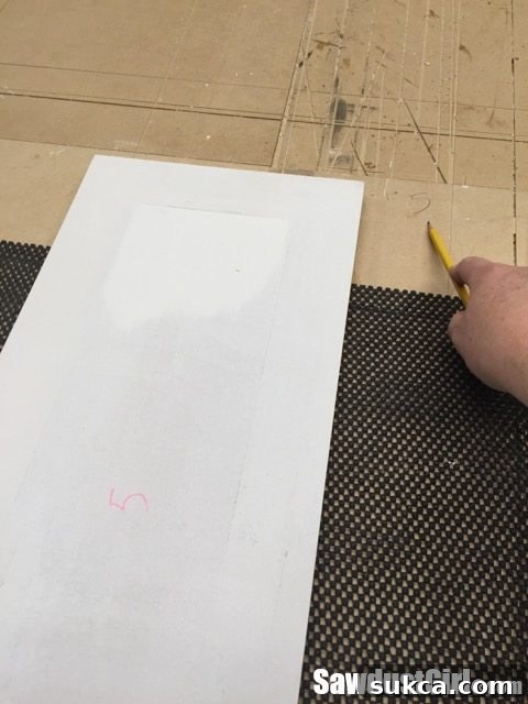 Priming Cabinet Backs Priming the entire back surface of a cabinet door for complete protection and consistent finish, with transferred dry-fit marks