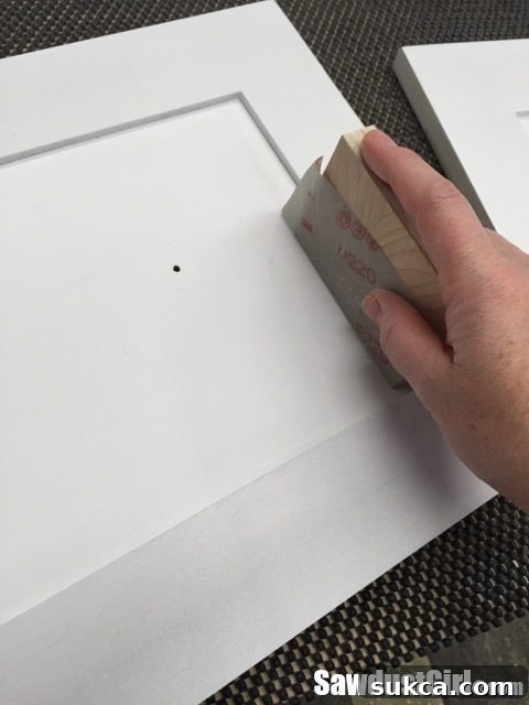 Sanding Cabinet Doors Lightly sanding all surfaces of a cabinet door with 220-grit sandpaper and a sanding block for optimal primer adhesion