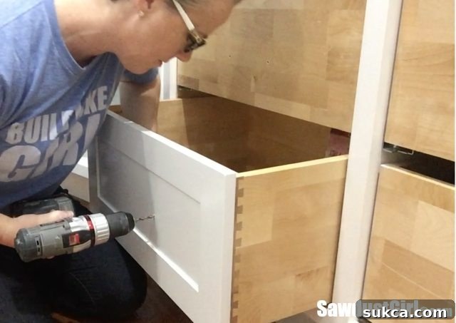 Drilling drawer pull holes through the drawer front with scrap wood backing