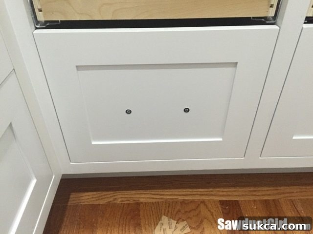 Temporarily securing the applied front to the drawer box with adjustment screws
