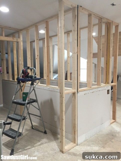 Transforming a loft into a highly functional space by extending stairway walls for maximum storage and organization.