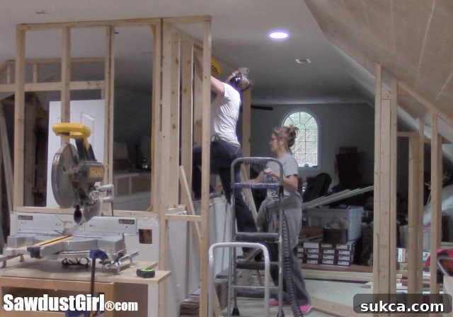 DIY loft renovation project showing the initial framing of extended stairway walls to create new storage opportunities.