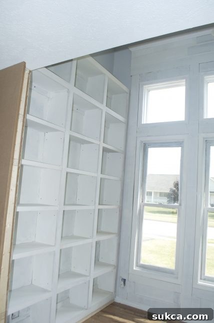Built-in bookcase cabinets under construction with emerging window trim