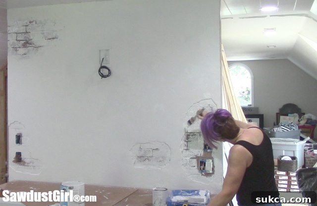 Dabbing Primer into Edges and Crevices of Faux Plaster Wall