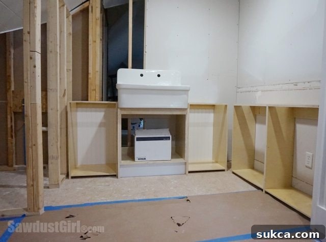 Utility Sink Plumbing Preparation Craft room utility sink installation showing temporary side cabinets for precise plumbing measurement