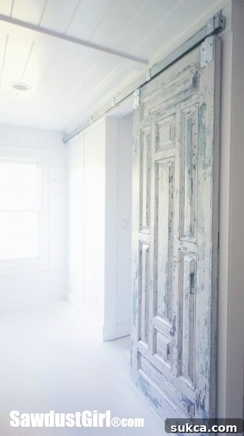 Chippy Paint Barn Door - The rustic chippy paint barn door installed over painted cork panels, serving as a stylish and functional entry to the closet.