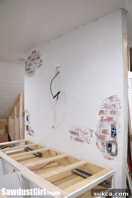 Chipped Plaster Brick Wall - Faux Technique - Another section of the studio featuring a newly finished chipped plaster faux brick wall, with electrical wiring ready for a TV installation.