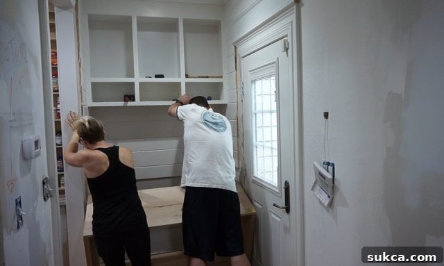 Installing heavy entry cabinet with help
