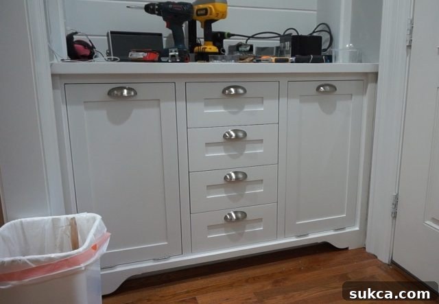 Installed Cup Pulls on Kitchen Hutch The finished lower section of the kitchen hutch, showcasing the decorative cup pulls elegantly installed on the perfectly aligned drawer fronts, adding a touch of sophistication.