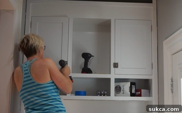 Completed Kitchen Hutch with Trash Can Integration A wide view of the kitchen entry hutch with all its doors and drawers installed and painted, featuring the decorative pulls and the integrated trash can, highlighting the complete and functional unit.