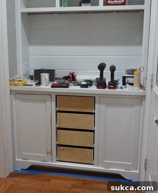 Drawer Test Fit in Kitchen Hutch A newly constructed drawer being carefully slid into place within the hutch opening, demonstrating the successful fit of the drawer box and glides.