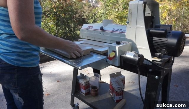 Sanding Drawer Fronts with a Drum Sander A drum sander in action, smoothing out a cabinet door or drawer front, demonstrating the process of achieving a perfectly flat surface for painting after puttying seams and nail holes.