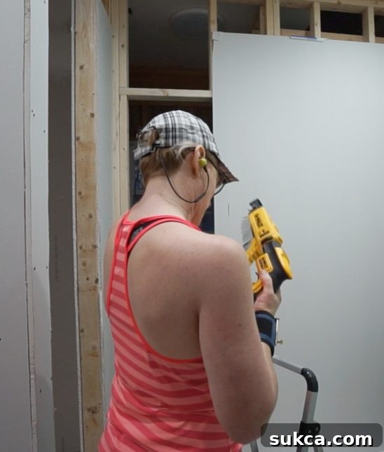 Efficient Drywall Installation Close-up of DeWalt collated screw gun in action, driving screws into drywall