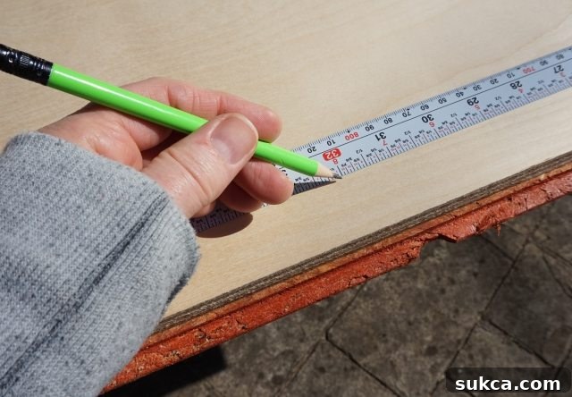 The Flatback tape measure being used to accurately measure a piece of wood for a woodworking project. Flatback measuring tape