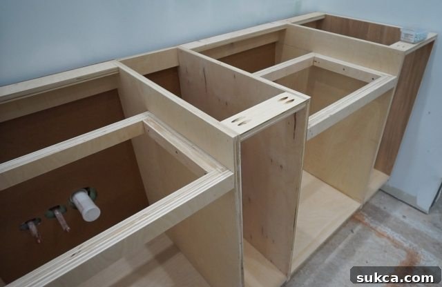 The top front cleat being installed on the completed vanity structure Installing Final Top Front Cleat on Vanity