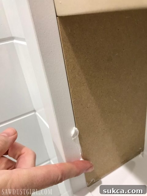 Caulking the seams of the recessed cabinet