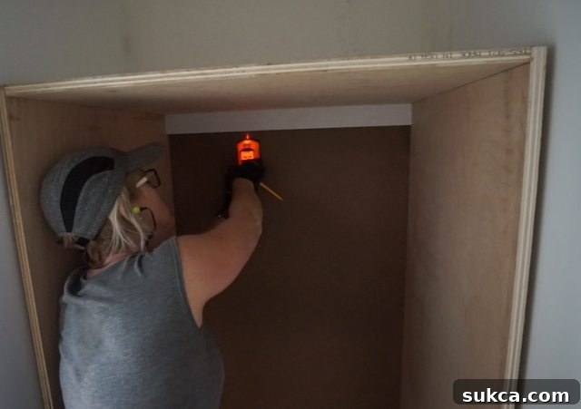 Using a Zircon stud finder to precisely locate studs for securing cabinets