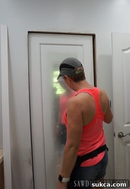 Installing a mirrored door, showing the door panel being fitted into the pocket door frame.