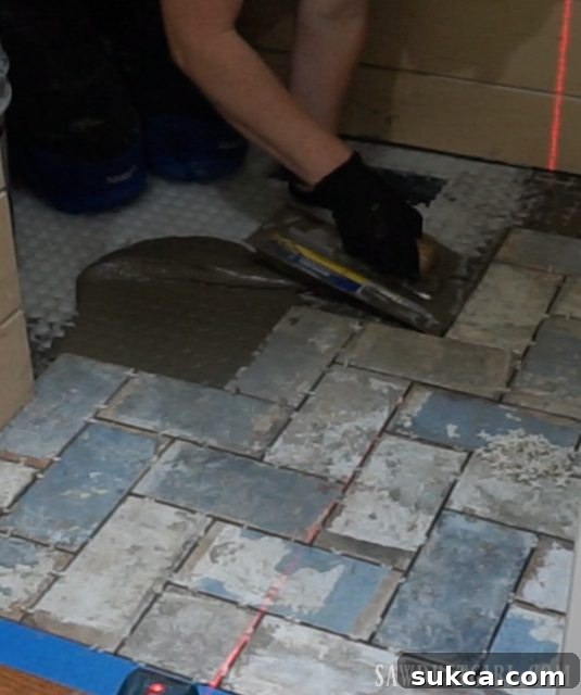 Working in sections to lay tile Setting herringbone brick tile flush with hardwood floor