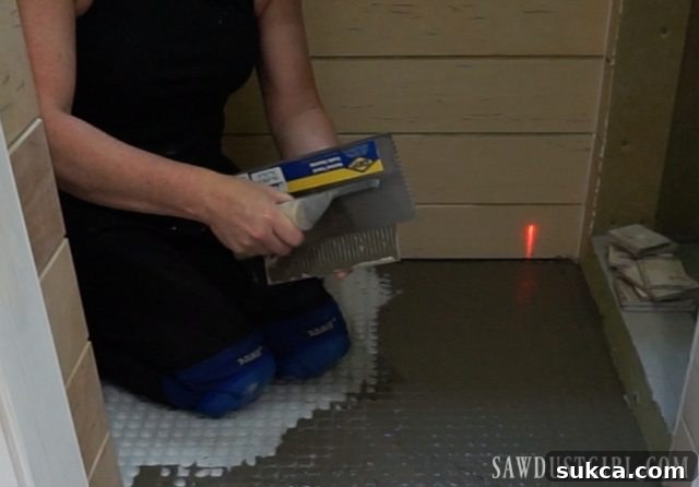 Applying mortar to the back of a tile Back-buttering tile for enhanced adhesion