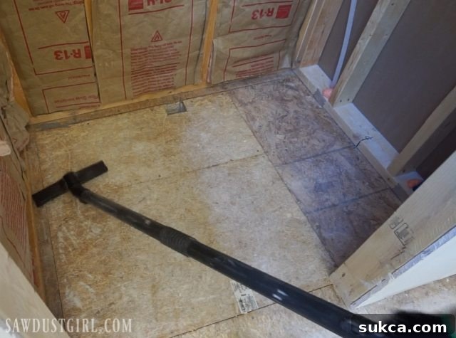 Tile ready shower pan installation: Drain pipe secured and subfloor prepared for pan.