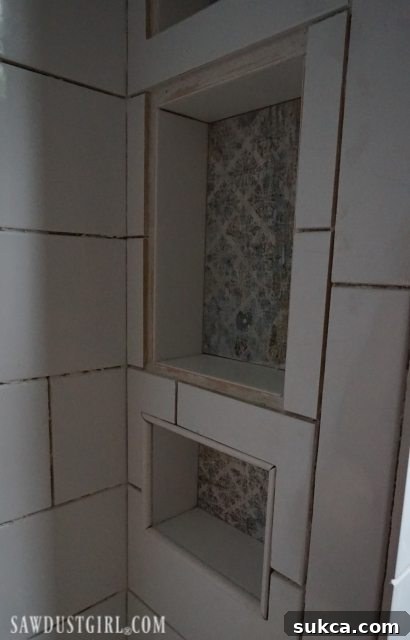 Tiling Around Shower Niches Tiling the Shower: Continuing the subway tile pattern around the shower niches, aiming for a uniform reveal for future trim.