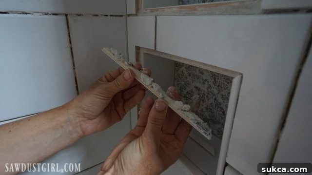 Bullnose Trim Installation on Shower Niches Tiling the Shower: Installing bullnose trim tile around shower niches, highlighting the challenge of mitered corners.