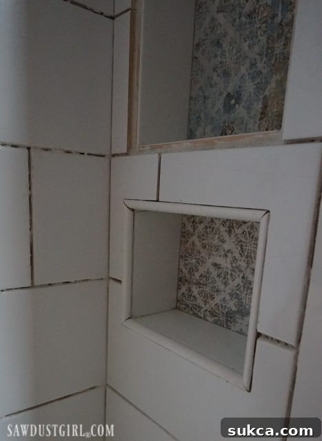 Finished Shower Niche with Bullnose Trim Tiling the Shower: A beautifully tiled shower niche with bullnose trim, showcasing the clean lines and finished look.
