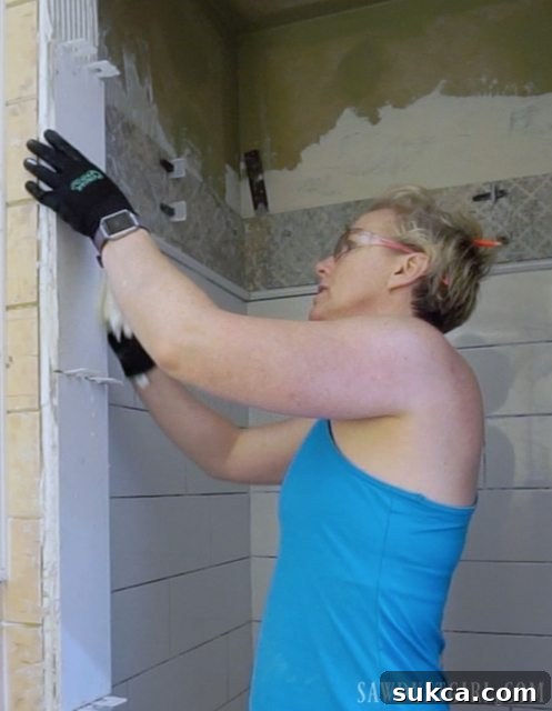 Vertical Subway Tile for Shower Doorway Tiling the Shower: Vertical installation of large format subway tiles around the shower doorway, crucial for a frameless glass door.