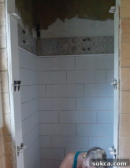 Improved Shower Doorway Tiling Tiling the Shower: The vastly improved appearance of the shower doorway with vertically installed large format subway tiles.