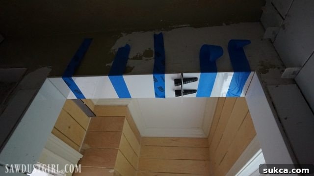 Mortar Adjustment and Painter's Tape Tiling the Shower: Using painter's tape to hold adjusted tiles in place while mortar cures at the top of the doorway.