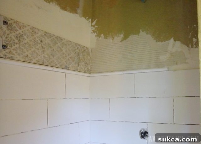 Decorative Pencil Liner Tile Installation Tiling the Shower: Installation of the decorative pencil liner tile to create an elegant border in the shower design.