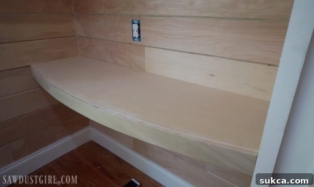 Curved floating desk securely attached to its support frame within a wall niche