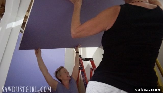 Teamwork involved in elevating drywall for ceiling installation