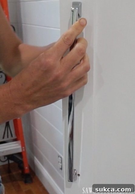 Integrated Storage for Compact Bedrooms 6 Attaching stylish Liberty hardware, including pulls and knobs, to newly installed closet doors.