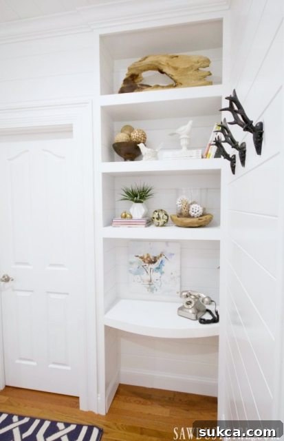 A closer look at the innovative desk nook in the guest bedroom, featuring custom-built floating shelves and a curved desk.