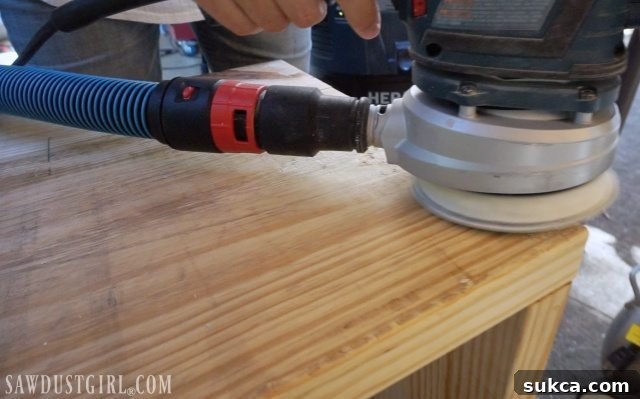 Sanding wood before staining with Briwax, ensuring a smooth surface for even wax application.
