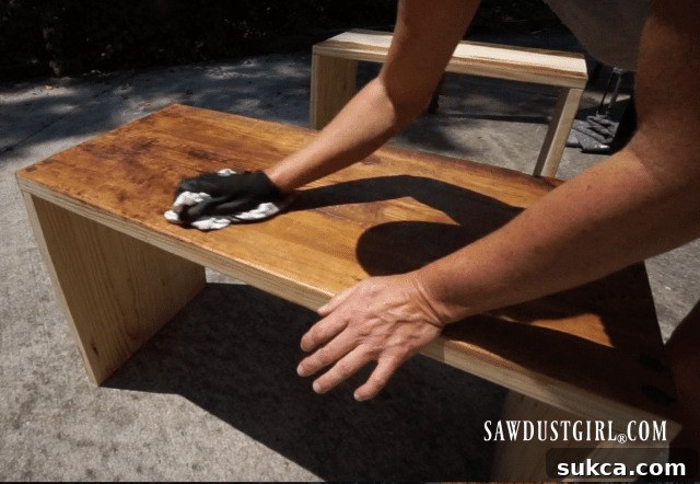 Applying light and dark brown Briwax to a wood table, showing the blending technique for multi-tonal finishing.