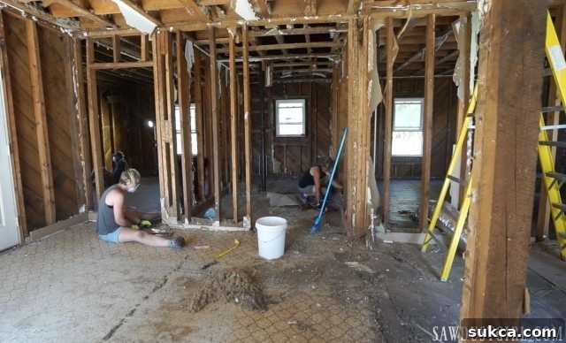 Extensive linoleum layers being removed during Calderwood Cottage demolition, revealing hidden damage