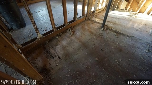 Damaged hardwood floors beneath multiple linoleum layers at Calderwood Cottage, revealing underlying issues