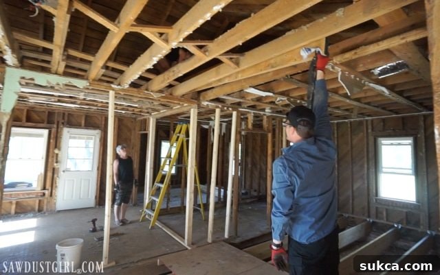 Wes single-handedly lifting the engineered beam into the attic Getting engineered beam into attic to support rafters