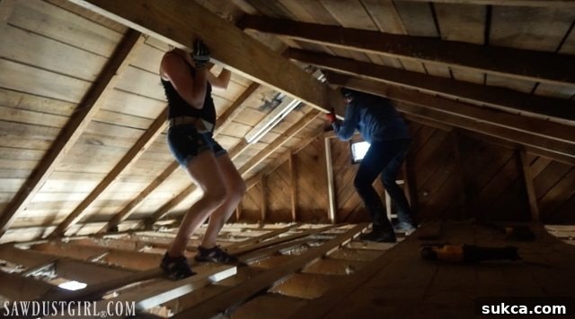 Teamwork securing the engineered lam beam in place Installing engineered beam to support the roof structure