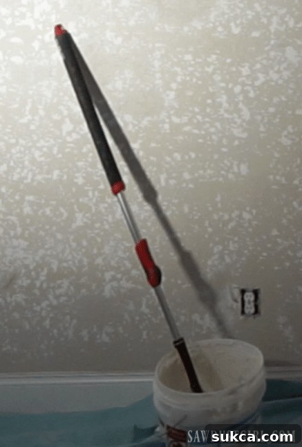 using paint roller to apply joint compound to walls before skimming smooth