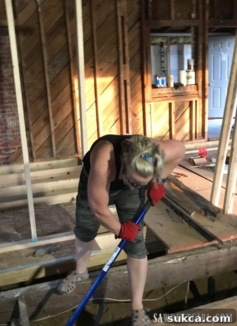 Physical labor during subfloor removal Tired but determined worker pulling nails