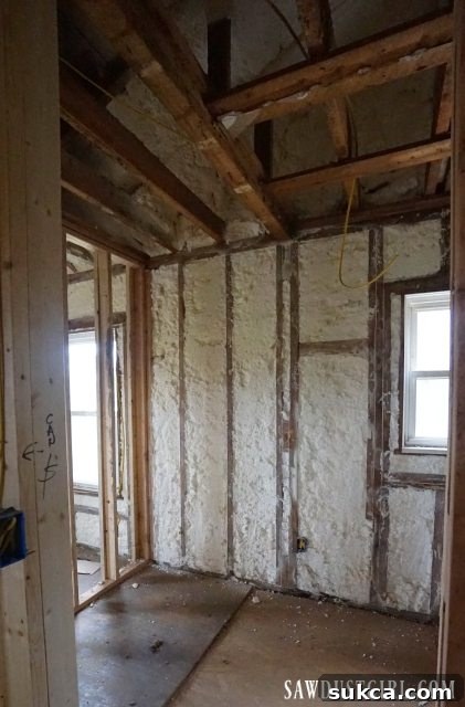 Insulating walls in progress Insulating walls with precision trimming of spray foam