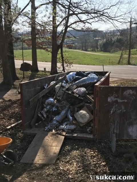 A large dumpster filled to its absolute brim with demolition waste, perfectly compacted and ready for collection, symbolizing a successful cleanup effort.