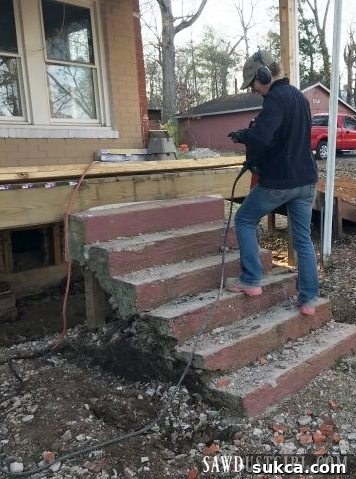 A close-up of a person using a jackhammer to break apart a concrete step, clearly revealing the hollow core and demonstrating the demolition process.