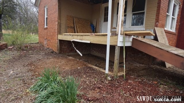 The front porch area after the successful demolition and removal of the concrete steps, showing a cleared and prepared space for new construction.