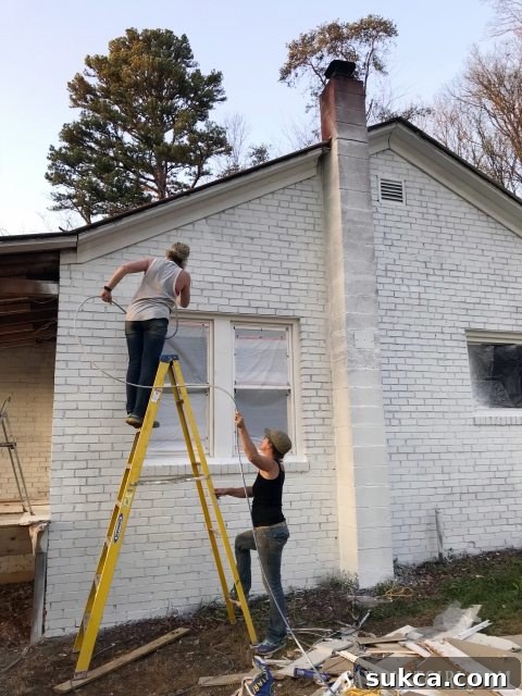 Applying paint to a brick house with an airless sprayer